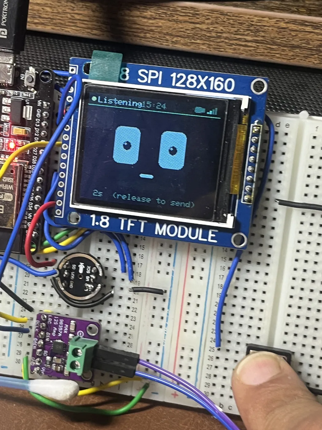 Buddy mid-conversation: the status bar reads "Listening", the timer shows two seconds elapsed, and the caption underneath says "release to send". A thumb is holding the SELECT button on the breadboard below.