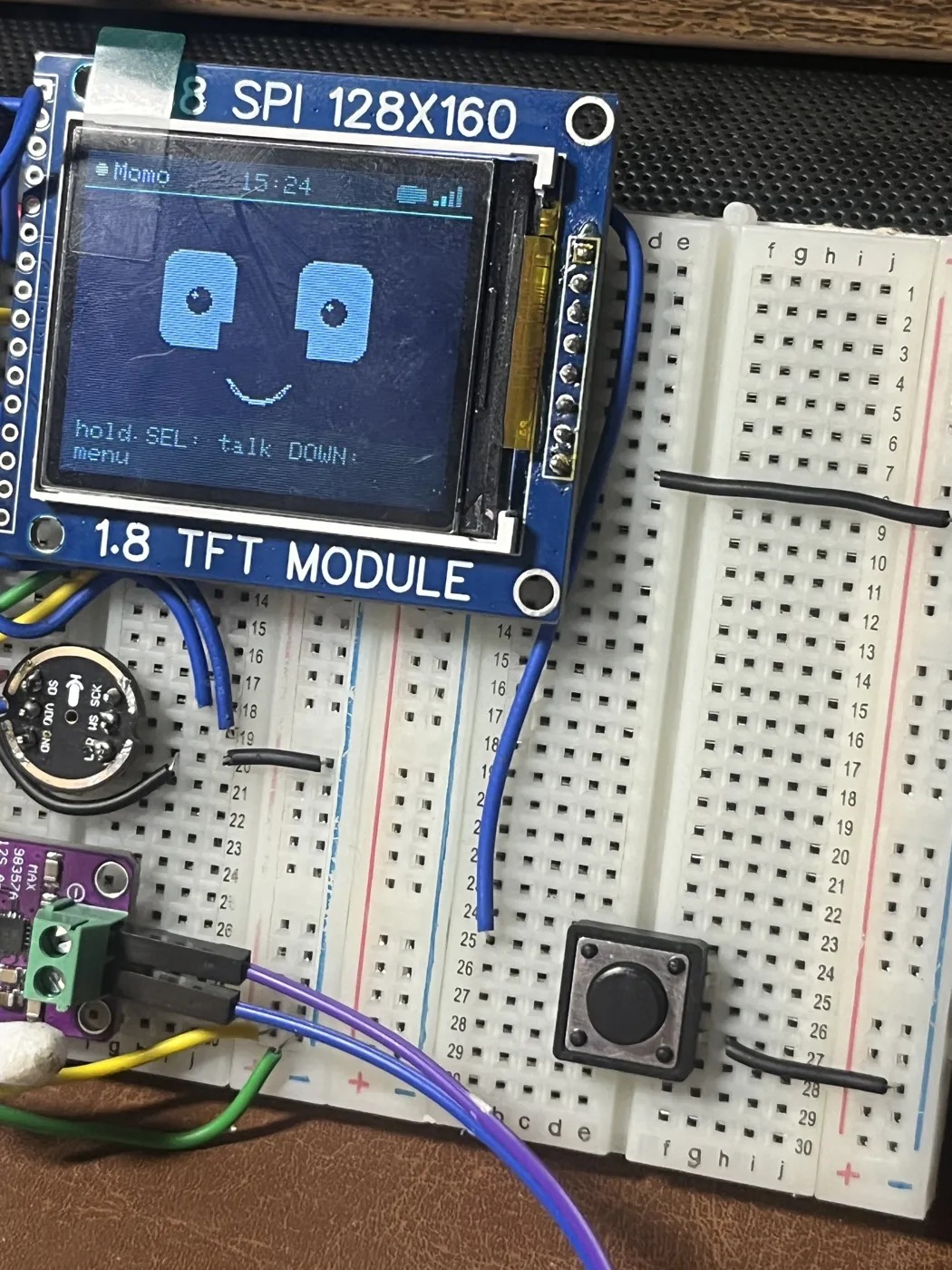 The same device running the Momo personality — different face, different colour theme, same firmware. The INMP441 microphone and MAX98357A amplifier sit on the breadboard underneath.